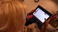 Nainen selaa verkkosivua tabletilla.