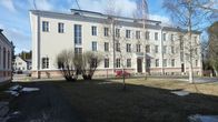 Kajaanin Seminaarin vanha päärakennus kylpee kevätauringossa.