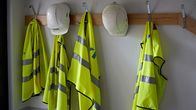 Turvaliivejä ja kypäröitä rakennustyömaan toimiston naulakossa.