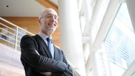 Professori Stuart Parkin kuvattuna avaraa toimistomaisemaa vasten.