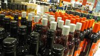 Alkoholijuomapakkauksia Alkon hyllyssä.