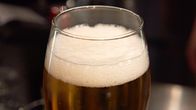 A foaming glass of beer.