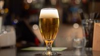 Beer in a stemmed glass on a bar.