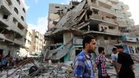 Palestiinalaismiehet tutkivat talojen raunioita Israelin ilmaiskun jälkeen Gazassa perjantaina 18. heinäkuuta 2014. 