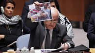 Palestiinalaisten YK-edustaja Riyad H. Mansour näytti kuvia pommitusten uhreista turvallisuusneuvoston kokouksessa New Yorkissa tiistaina 22. heinäkuuta 2014.
