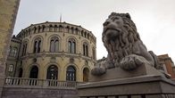 Leijonapatsas vartioi Norjan parlamenttirakennuksen ulkopuolella.