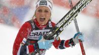 Norjan Therese Johaug juhlii voittoa sukset ja sauvat käsissään.