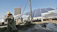 Kiinalaiset työntekijät pystyttävät valtavaa aurinkopaneelia Tianjinissa.