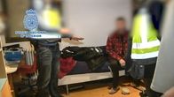poliisit puhuttelevat epäiltyä tämän asunnossa