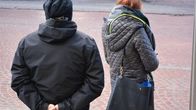 Mies ja nainen odottamassa bussia.