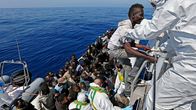 Valokuvassa Italian viranomaiset auttavat veneessä olevia siirtolaisia laivaansa 22. huhtikuuta. Veneessä oli arviolta 200 matkustajaa.