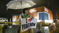 Fergusonin asukas Kathy Magrecki  seisoo sateessa poliisilaitoksen edessä.