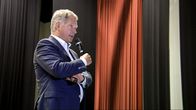SAULI NIINISTÖ puhuu mikrofoniin