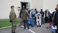 Pihanvalvoja seuraa turvapaikanhakijoiden rekisteröitymistä Tornion järjestelykeskuskessa.