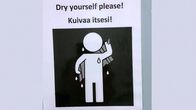 Ohjekyltti, jossa teksti Dry yourself please! Kuivaa itsesi!