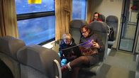 Nainen lukee pojalle junanvaunussa.