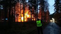 Toimittaja ottaa valokuvaa NIinisalossa roihuavasta kerrostalopalosta.