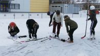 Kahdeksasluokkalaiset tytöt pukevat luistimia jääkentän reunalla.