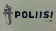 Oulun poliisilaitoksen kyltti valkoisella pohjalla ja sininen teksti.