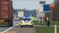 Poliisiauto vilkut päällä moottoririen pientareella, vieressä neljä poliisia huomioliiveissä. Kyltit kertovat, että ollaan Tanskan kuningaskunnan ja EU:n rajalla. 