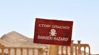 Varoituskyltti hengenvaarasta. Isis-järjestö jätti vetäytyessään räjähteitä Palmyran rauniokaupunkiin. Venäläiset sotilaat ovat raivanneet alueelta miinoja.