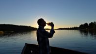 Mies juo alkoholia veneellä.