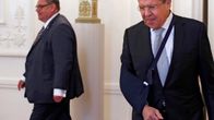 Timo Soini ja Sergei Lavrov kävelevät eri suuntiin. Lavrovilla on käsi paketissa. 