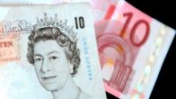 Kuva 10 punnan ja 10 euron seteleistä. 10 punnan setelissä on kuningatar Elisabet toisen kuva. Euron seteli on lohenpunainen.