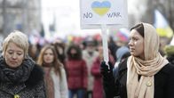 Nainen pitelee No war -kylttiä.