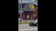 Kuvakaappaus videosta, jossa näkyy kuinka mies aloittaa ammuskelun jalkakäytävällä.