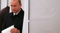 Putin tulee ulos äänestyskopista äänestyskuori kädessään.