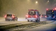 Ambulanssi ja autoja lumipyryssä