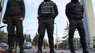 Kolme poliisia sammakkoperspektiivissä. Maassa punaisia neilikoita.
