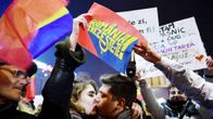 Nuori pari suutelee mielenosoituksessa Romanian Bukarestissa.
