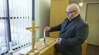 Pappi sytyttää kynttilää seurakuntakeskuksen kappelin alttarilla. Kuvassa Kuusankosken kirkkoherra Kimmo Ylikangas