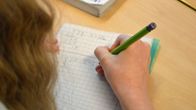 Tyttö laskee matematiikan tehtävää.
