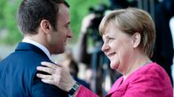 Macron ja Merkel tervehtivät.