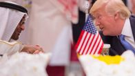 Abu Dhabin kruununprinssi ja Trump kättelevät. Etualalla pöydällä on pieni Yhdysvaltain lippu.