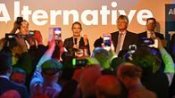 Kännykkäkamerat nostettu ilmaan kuvaamaan Alternative-tekstin edessä seisovia ihmisiä.