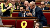 Roger Torrent istuu parlamenttisalissa. Ympärillä muut edustajat taputtavat.