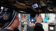 Autoasentaja kuvaamassa videota auton alla