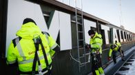 Metallityöväenliiton kylttiä irroitetaan Hakaniementie 1:n katolla