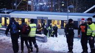 ihmisiä junan edustalla ja poliiseja