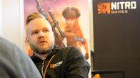 NitoGames pelifirman toimitusjohtaja Jussi Tähtinen istuu työpaikallaan, taustalla yrityksen roll-up