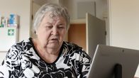 Ikäihminen katsoo tablettitietokonetta.