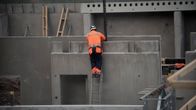 Mies työskentelee rakennustyömaalla.
