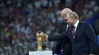 Venäjän presidentti Vladimir Putin ojentaa kättään ja koskettaa jalkapallon MM-kisojen palkintopokaalia Moskovassa finaalin jälkeen 15. heinäkuuta 2018. Putinin vieressä kansainvälisen jalkapalloliiton puheenjohtaja Gianni Infantino.