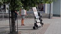 Jehovan todistajia lehtitelineen vieressä.