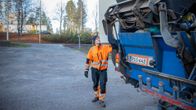 Jäteauton kuljettaja Elias Sibakov tyhjentää jäteastioita autoon.