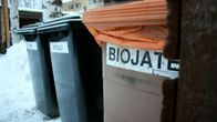Jäteastiat biojätteelle, metallille ja lasille kerrostalon pihalla.